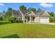 Well-maintained home featuring a manicured lawn, attached garage, and inviting front porch with charming details at 825 Payne Ct., Conway, SC 29526