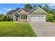 Charming single-story home featuring a manicured front lawn, two-car garage, and rocking chairs on the front porch at 825 Payne Ct., Conway, SC 29526