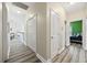 Hallway with neutral walls and wood-look floors leading to a bedroom with green walls at 825 Payne Ct., Conway, SC 29526