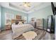 Comfortable main bedroom featuring tray ceiling, wood-style floors, and natural light at 825 Payne Ct., Conway, SC 29526