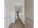 Entryway featuring hardwood flooring, white walls, and a view leading down the brightly lit hallway at 8500 Dunes Point Way, Longs, SC 29568