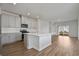 Open kitchen featuring stainless appliances, white cabinets, island and wood-look flooring at 8500 Dunes Point Way, Longs, SC 29568