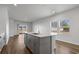 Kitchen island with sink and dishwasher overlooks a living area and sliding glass door at 8500 Dunes Point Way, Longs, SC 29568