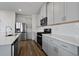 Kitchen with stainless appliances, white cabinets, modern backsplash and wood-look flooring at 8500 Dunes Point Way, Longs, SC 29568