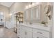 Bright bathroom featuring double vanity with white cabinets, modern fixtures, mirror, and a decorative gold shelving unit at 949 Crystal Water Way, Myrtle Beach, SC 29579