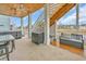 A covered outdoor living area with a staircase, outdoor sink, storage bench, and hot tub overlooking the water at 949 Crystal Water Way, Myrtle Beach, SC 29579