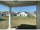 View of a white house and lush, green backyard, as seen from covered patio at 969 Oak Hollow St., Longs, SC 29568