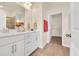 Bathroom with double sink, white cabinets, framed mirrors, a walk-in shower, and a glimpse into the walk-in closet at 969 Oak Hollow St., Longs, SC 29568