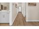 Well-lit hallway featuring wood floors, neutral paint, and doors leading to different rooms of the house at 969 Oak Hollow St., Longs, SC 29568