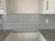 Close-up of a kitchen with a geometric gray backsplash and granite countertops at 969 Oak Hollow St., Longs, SC 29568