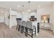 Chic kitchen boasts white cabinets, a contrasting dark island, and sleek barstool seating at 969 Oak Hollow St., Longs, SC 29568