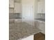 Modern kitchen featuring granite countertops, white cabinets, and stylish backsplash at 969 Oak Hollow St., Longs, SC 29568