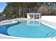 A shared community pool with sun loungers, umbrellas, and trees in background at 969 Oak Hollow St., Longs, SC 29568