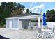 Exterior of a pool house with lounge seating, tables, and an emergency shutoff at 969 Oak Hollow St., Longs, SC 29568