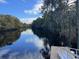Beautiful calm river view with lush green trees along the banks and a small pier at 969 Oak Hollow St., Longs, SC 29568