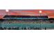 Wide stadium view showcasing vibrant football field, filled stands under a colorful dusk sky at 969 Oak Hollow St., Longs, SC 29568
