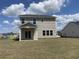 View of the home's backyard with a covered porch and ample lawn space, perfect for outdoor activities at 990 Oak Hollow St., Longs, SC 29568