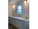 Bright bathroom featuring a double sink vanity with white cabinets and a window at 990 Oak Hollow St., Longs, SC 29568