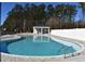 Outdoor community pool with crystal-clear water and poolside lounge chairs surrounded by trees and a white fence at 990 Oak Hollow St., Longs, SC 29568