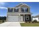 Charming two-story home with a two-car garage, stone accents, and a well-manicured lawn at 990 Oak Hollow St., Longs, SC 29568