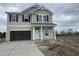 Two-story house with attached garage and a yard in an early stage of development at 990 Oak Hollow St., Longs, SC 29568