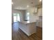 Open kitchen design features white cabinets and a spacious island with breakfast bar seating at 990 Oak Hollow St., Longs, SC 29568