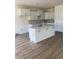 Kitchen boasts white cabinets, island with sink, and luxury vinyl flooring at 990 Oak Hollow St., Longs, SC 29568