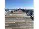 View of a pier on a sunny day with blue skies, wooden planks, benches, and people in the distance at 990 Oak Hollow St., Longs, SC 29568