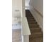 Carpeted staircase with wood handrail leading to the upper level at 990 Oak Hollow St., Longs, SC 29568