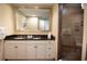 Bathroom featuring double sinks with black granite countertops, a large mirror, and a walk-in shower at 100 North Beach Blvd. # 1917, North Myrtle Beach, SC 29582