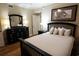 Inviting bedroom featuring a queen bed, dark wood furniture, neutral walls and wood-look laminate flooring at 100 North Beach Blvd. # 1917, North Myrtle Beach, SC 29582