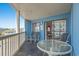 Inviting balcony with seating, offering views of the building, ocean, and beach at 1000 N Waccamaw Dr. # 205, Murrells Inlet, SC 29576