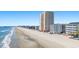 A beachfront view of an oceanfront tower and the beach with other hotels and attractions visible at 1000 N Waccamaw Dr. # 205, Murrells Inlet, SC 29576