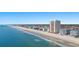 Wide beachfront view of an oceanfront tower, beach, and hotels with the treeline of a neighborhood visible at 1000 N Waccamaw Dr. # 205, Murrells Inlet, SC 29576
