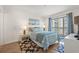Well-lit bedroom showcasing a queen bed, balcony access, and beach-themed artwork at 1000 N Waccamaw Dr. # 205, Murrells Inlet, SC 29576