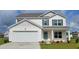 Charming two-story home featuring a two-car garage, teal door, and landscaped yard at 1005 Garden Sprout Dr, Galivants Ferry, SC 29544