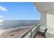 This balcony features chairs and a stunning view of the tranquil ocean and sandy beach at 107 S Ocean Blvd. # 1002, Myrtle Beach, SC 29577