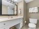 Well-lit bathroom featuring a vanity with a sink and toilet with plush towels at 107 S Ocean Blvd. # 1002, Myrtle Beach, SC 29577