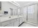 Bathroom featuring double sinks, white cabinetry, and a glass-enclosed shower at 1201 Trisail Ln, North Myrtle Beach, SC 29582