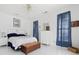 Bright bedroom with white tile floors, blue accents, and a chest at the foot of the bed at 1201 Trisail Ln, North Myrtle Beach, SC 29582