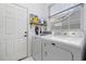 Clean laundry room with updated machines, a window for natural light, and shelving at 1201 Trisail Ln, North Myrtle Beach, SC 29582