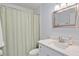 Updated bathroom with white vanity, countertop, framed mirror and a shower with sage green curtain at 128 Beaver Pond Loop # 48, Pawleys Island, SC 29585