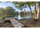 Scenic lake view with a private dock, surrounded by lush greenery and mature trees at 128 Beaver Pond Loop # 48, Pawleys Island, SC 29585