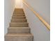 Carpeted staircase with a wooden handrail provides access to the upper level of the home at 128 Beaver Pond Loop # 48, Pawleys Island, SC 29585