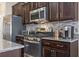 A modern kitchen featuring stainless steel appliances, granite countertops, and dark wood cabinets at 135 Parmelee Dr. # A, Murrells Inlet, SC 29576