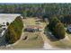 Expansive aerial view of a single-story home with a large yard surrounded by trees and nearby outbuildings at 140 Flag Patch Rd., Loris, SC 29569