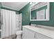 Green bathroom featuring a shower-tub combo and vanity with framed mirror at 140 Flag Patch Rd., Loris, SC 29569