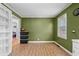 Eat in dining room with olive green walls featuring wood grain floors, a window, and storage shelving at 140 Flag Patch Rd., Loris, SC 29569