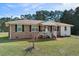 Inviting brick home featuring a cozy front porch and well-maintained front yard at 140 Flag Patch Rd., Loris, SC 29569