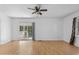 Bright living room with wood grain flooring, a ceiling fan, and access to the back porch through sliding glass doors at 140 Flag Patch Rd., Loris, SC 29569